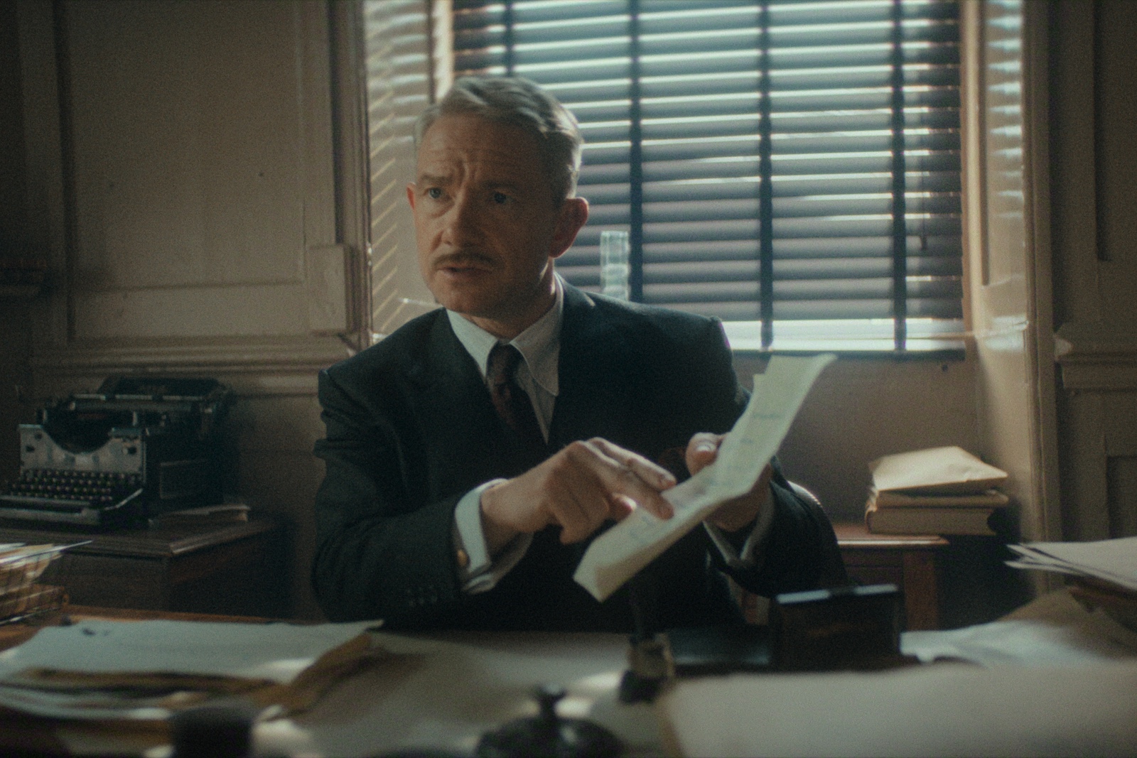 Martin Freeman in 'Battle' in Agatha Christie's Seven Dials Mystery (Photo credit: Netflix/Simon Ridgeway). Scene filmed on location at the Corn Exchange offices above St Nicholas Market, facilitated by Bristol Film Office.